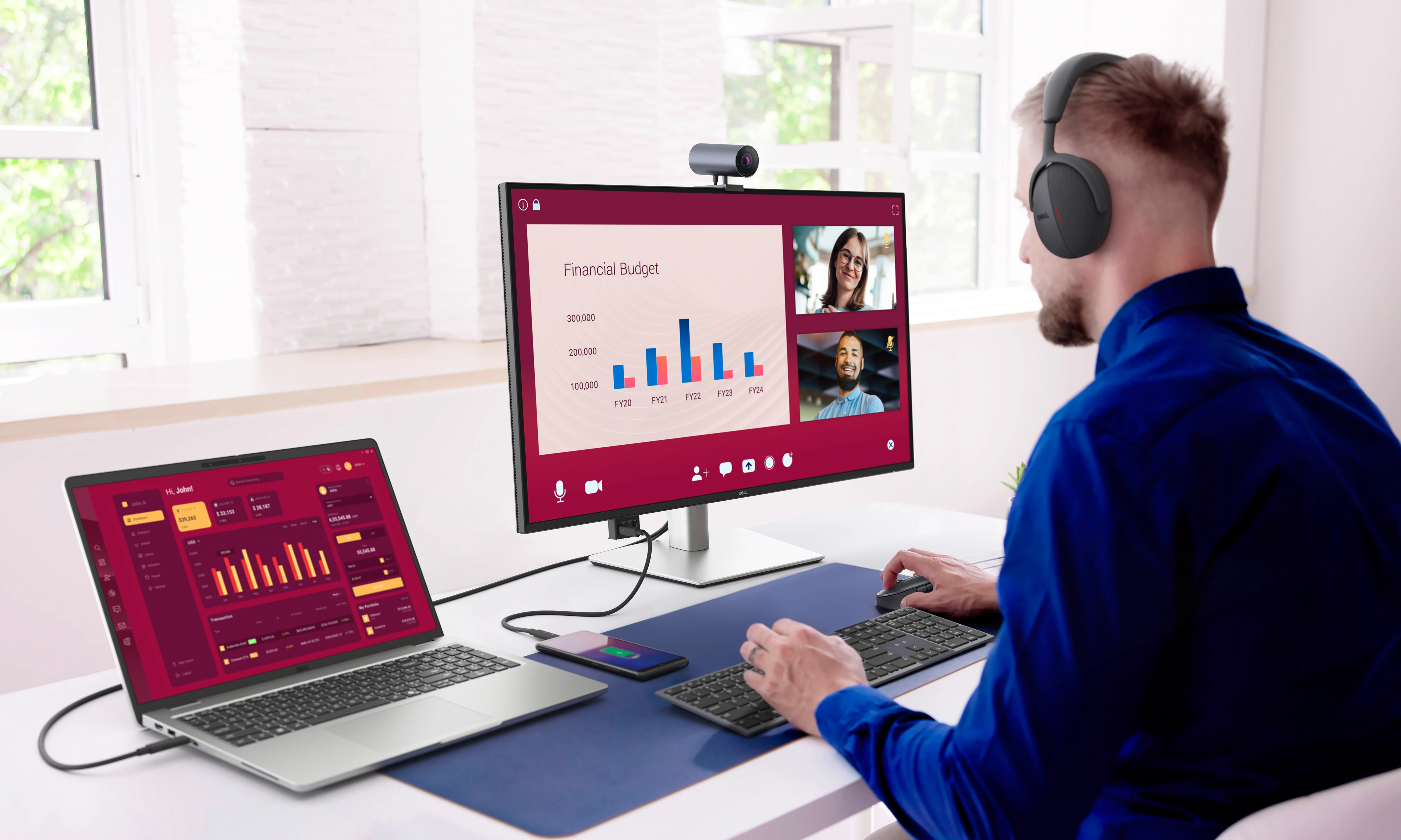 Một doanh nhân đang làm việc trên màn hình Dell Pro 32 Plus 4K USB-C Hub, được kết nối với máy tính xách tay, trong khi đeo tai nghe.